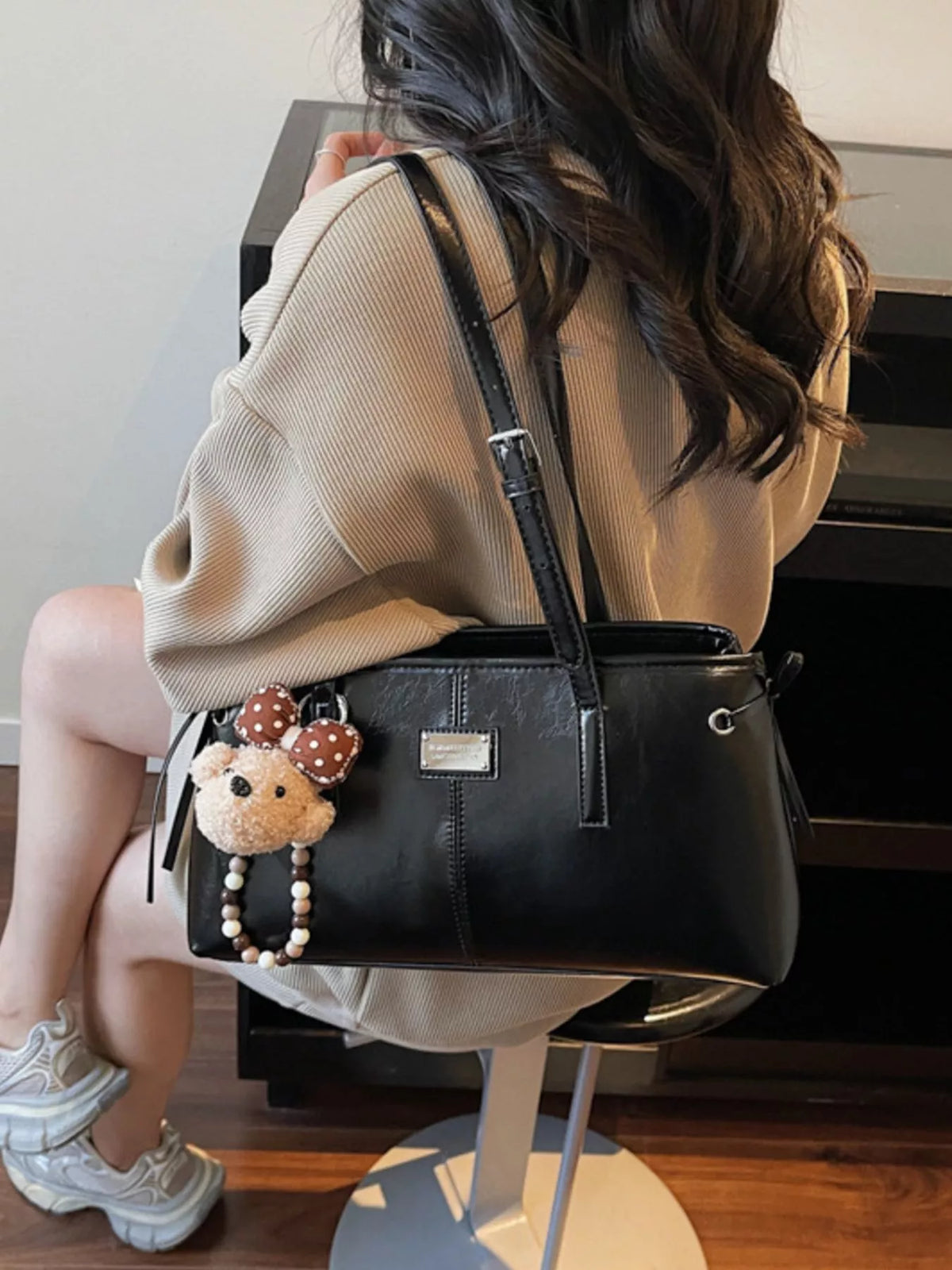 Black vegan leather medium shoulder bag with top handles and beaded teddy accessory