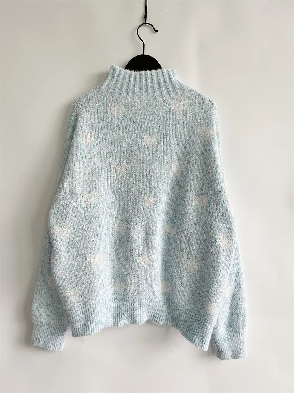 Heart-patterned heathered light blue turtleneck drop-shoulder sweater, back view hanging