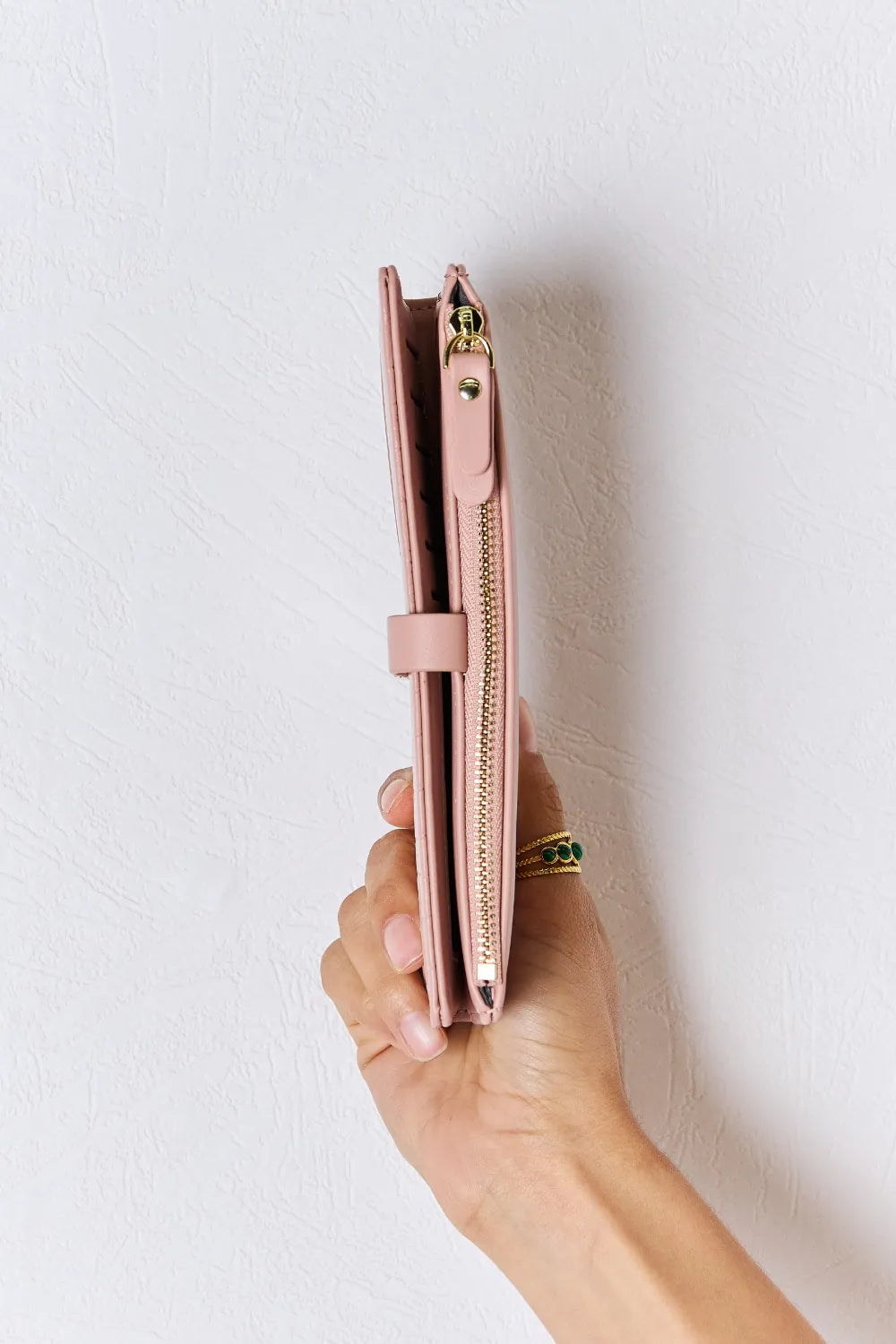 Pink textured PU leather wallet with side zipper and gold-tone hardware, held upright.