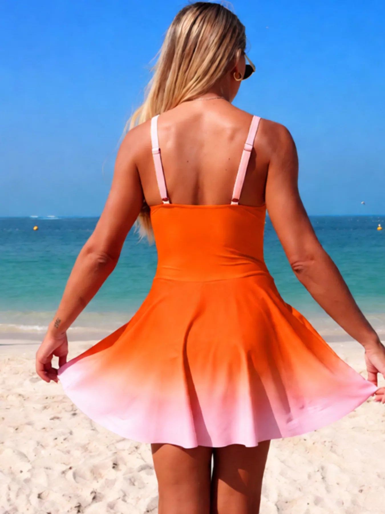 V-Neck Gradient One-Piece Swimsuit back view with orange-to-pink gradient and pink straps on model at the beach