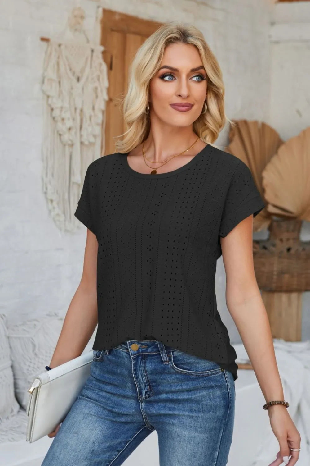 Black eyelet short-sleeve T-shirt with round neck and subtle vertical cutout pattern