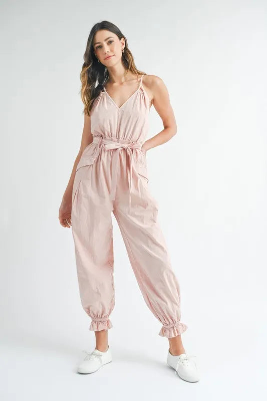 Pink washed-fabric spaghetti strap jumpsuit with waist belt and gathered ankle cuffs