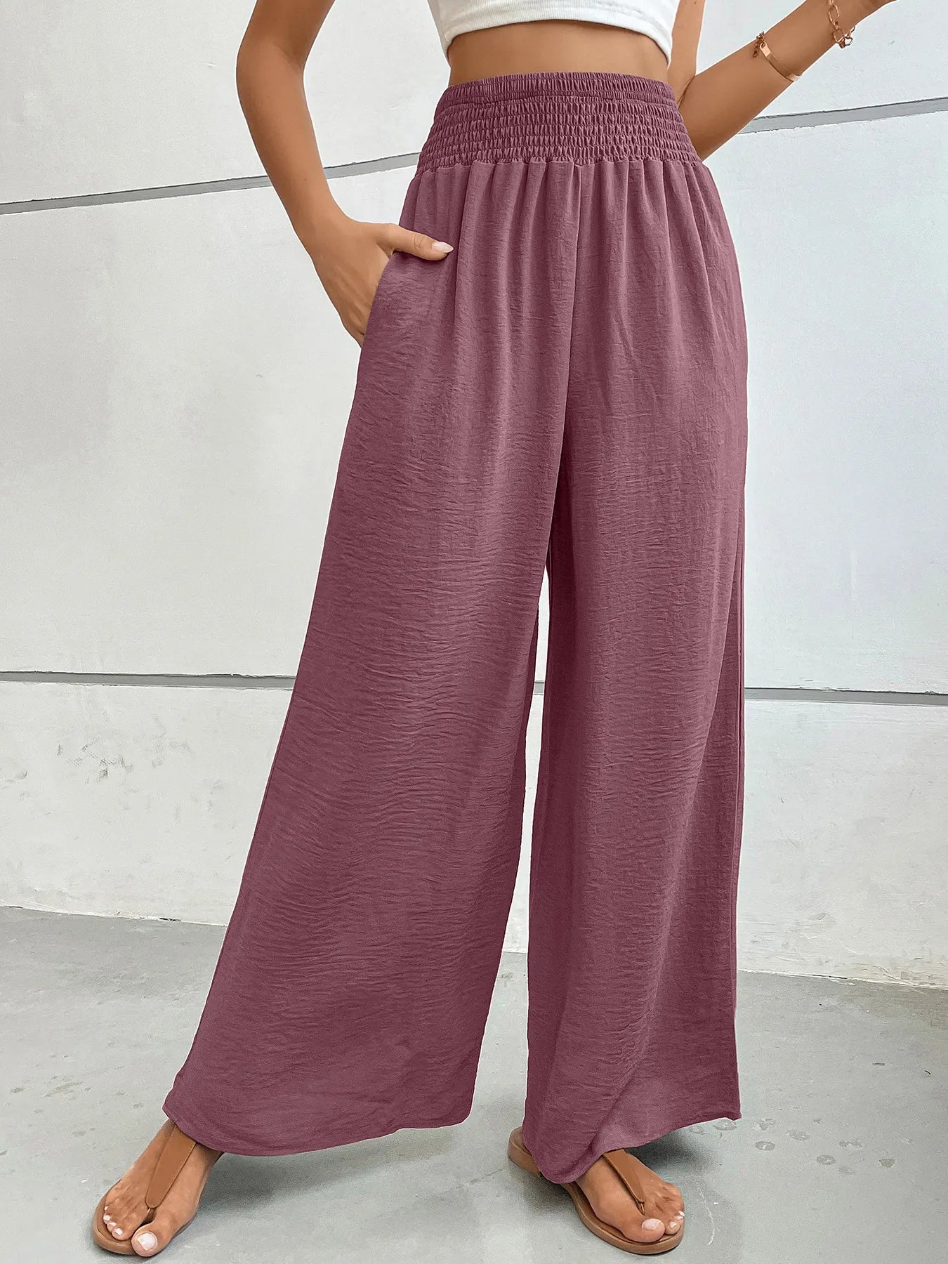 High-waisted wide-leg pants in plum with elastic smocked waistband and flowing wide legs.