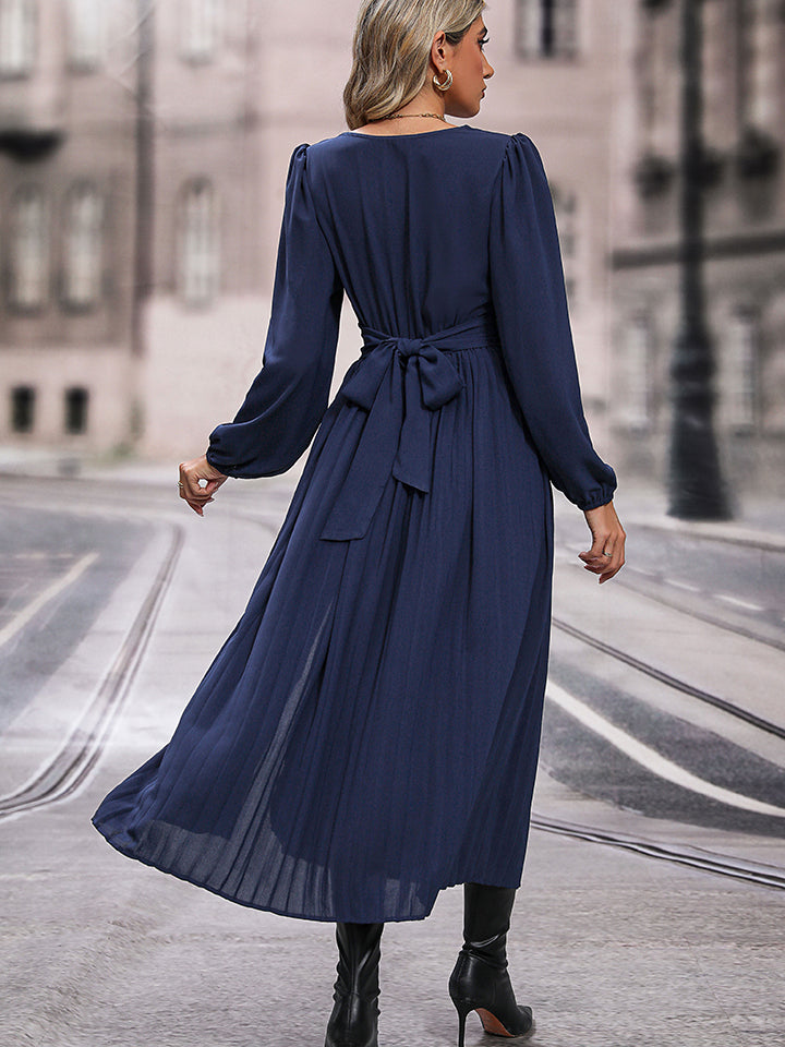 Dark blue V-neck long sleeve pleated dress with waist tie, back view