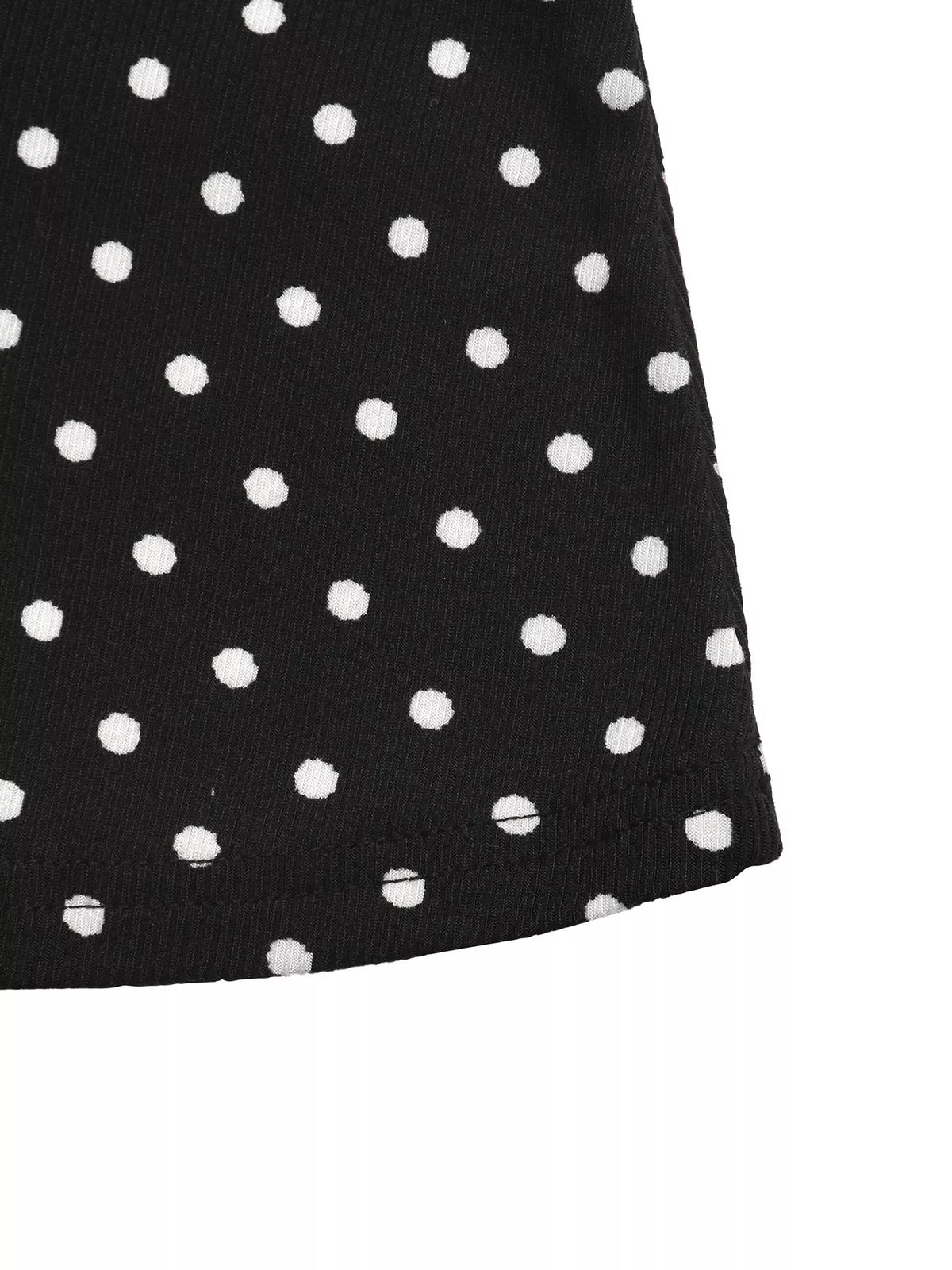 Black polka dot mini dress hem close-up with short flared shape