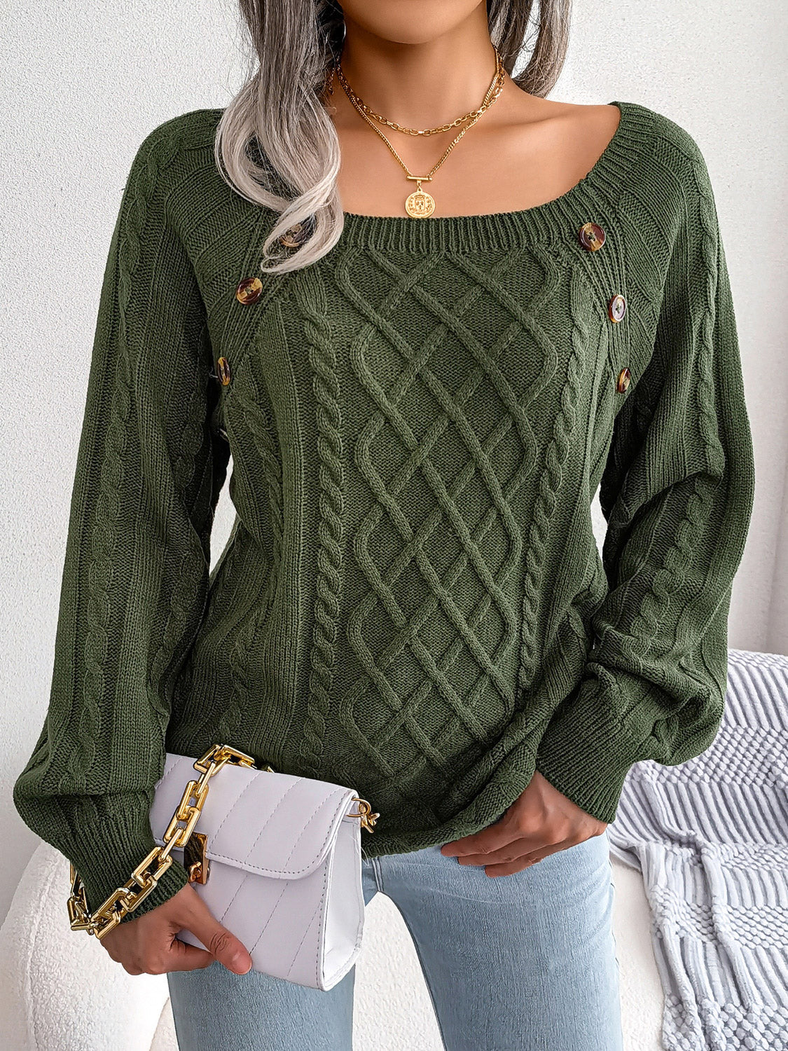 Dark green cable-knit sweater with diamond lattice knit and decorative button accents