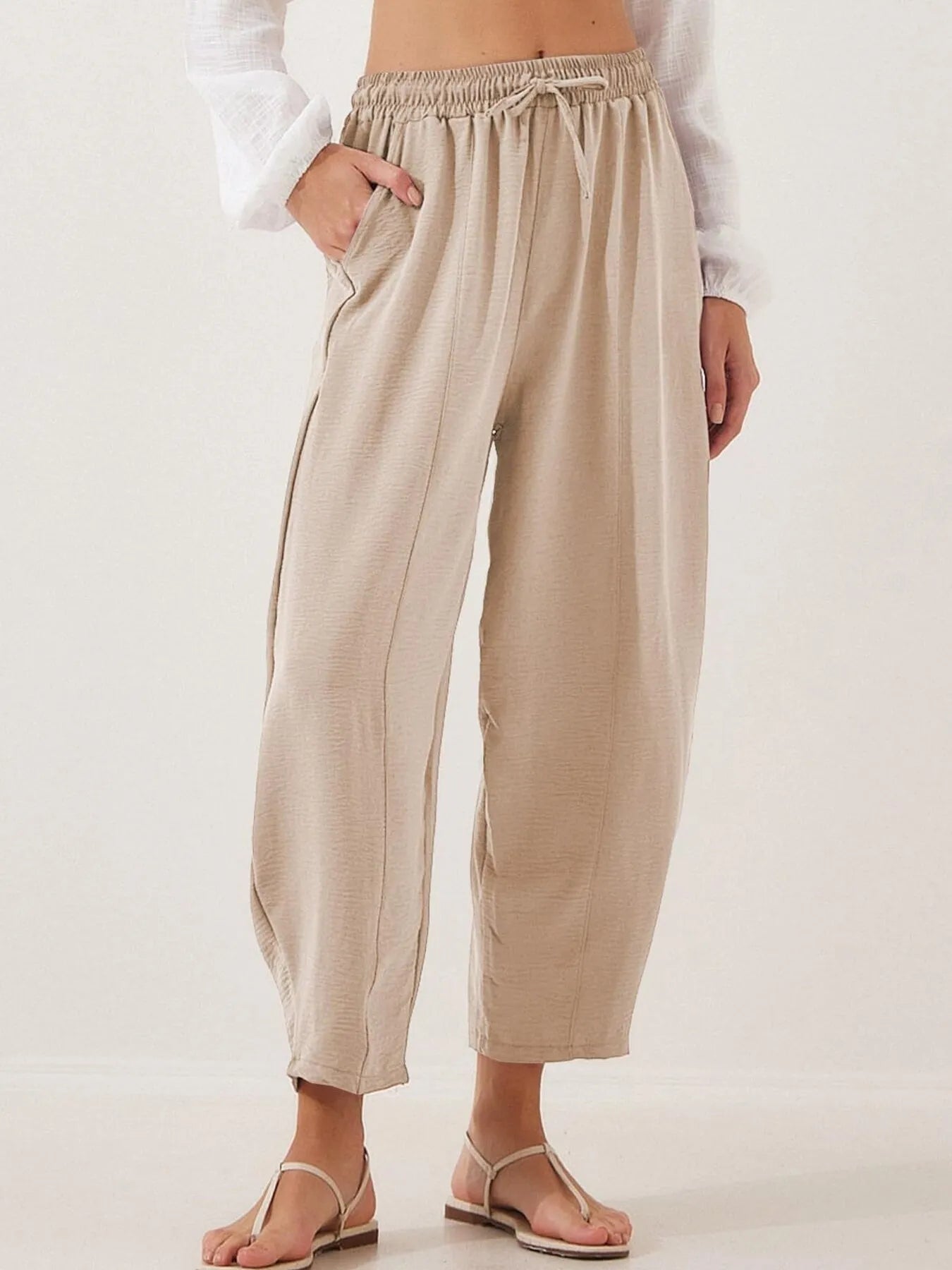 Beige cropped wide-leg drawstring pants with elastic waistband, relaxed fit
