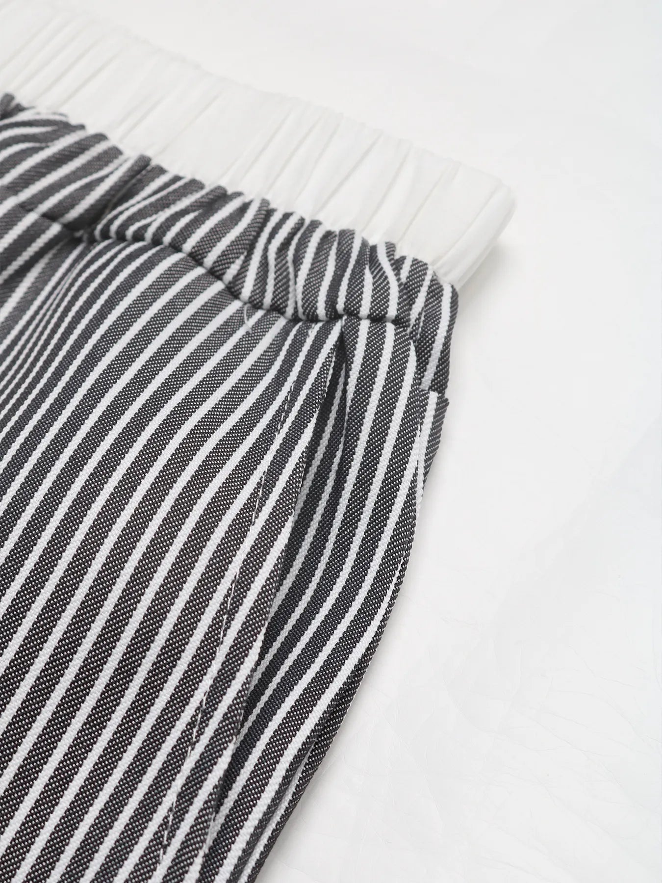Striped wide-leg pants hem detail with elastic waistband, black and white vertical stripes