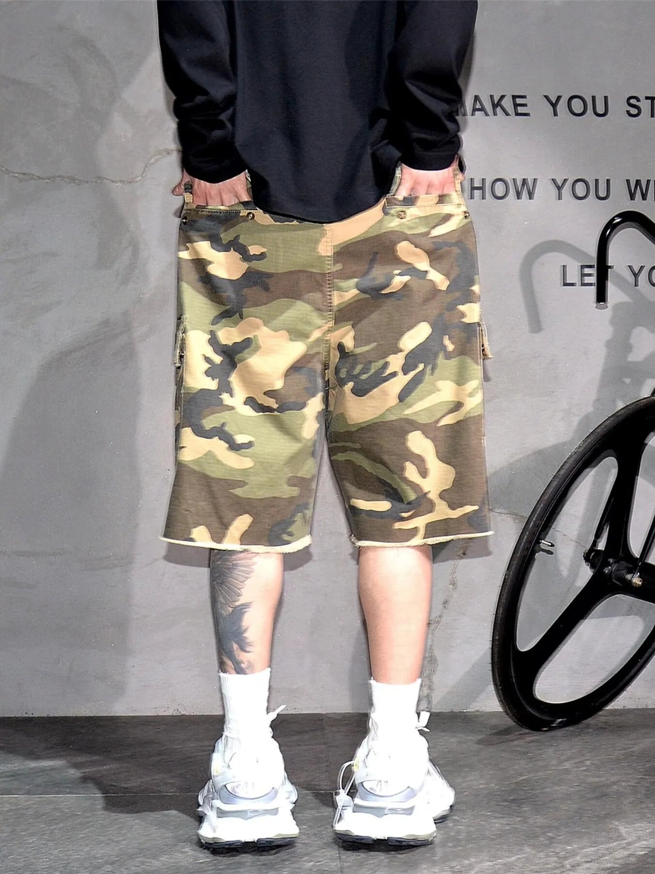 Light green camouflage cargo shorts with patch pockets and knee-length hem