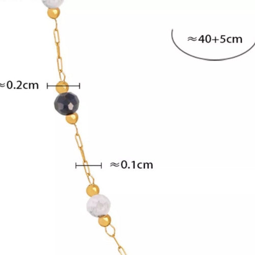 Gold chain necklace with faceted dark center bead and pastel bead accents