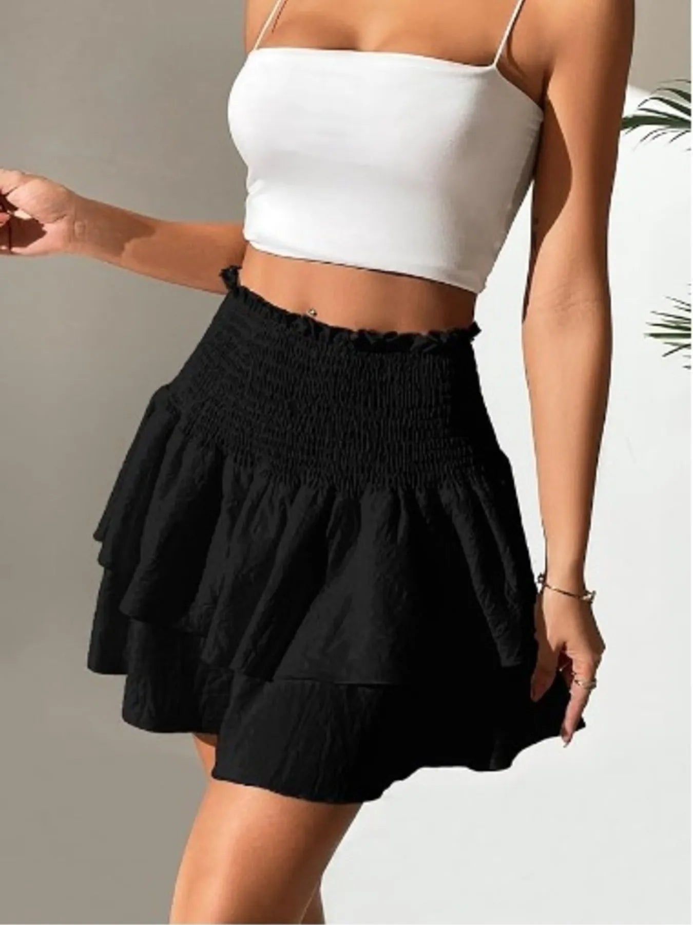 Black smocked layered mini skirt with gathered waist and fluttering tiered hem