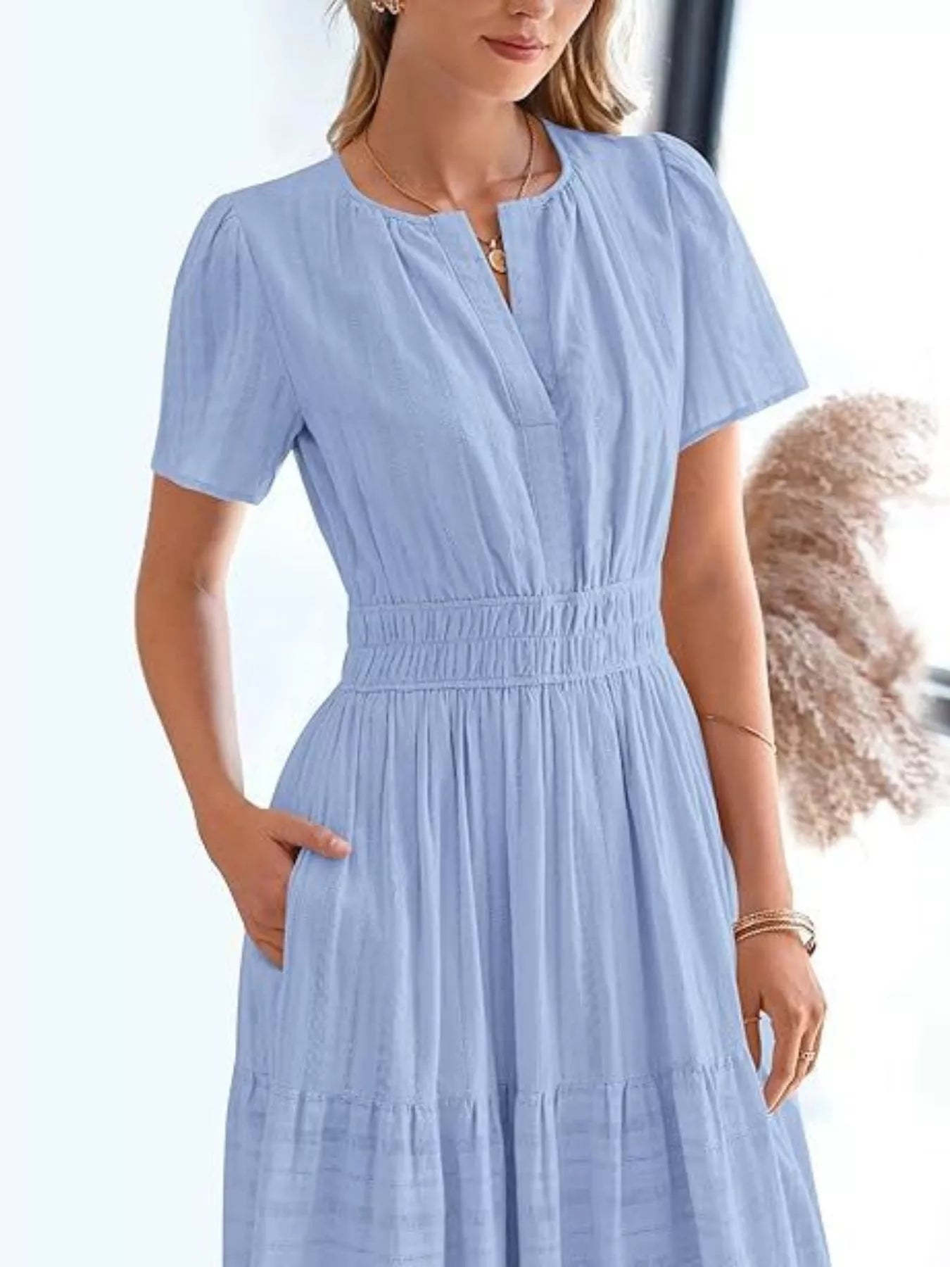 Tiered midi dress in light blue, gathered smocked waist, V-neck, short sleeves, tiered hem.