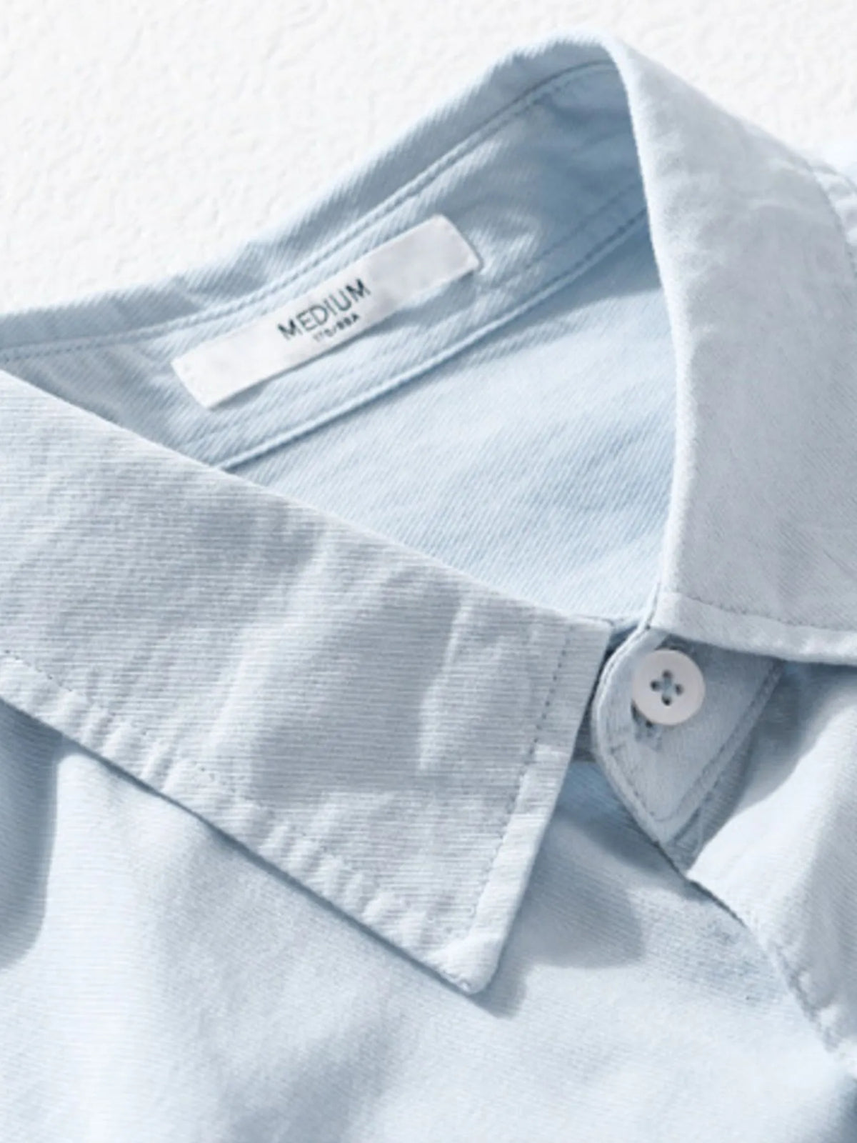 Men's short-sleeve cotton button-up shirt, light blue collar and buttons, size tag visible