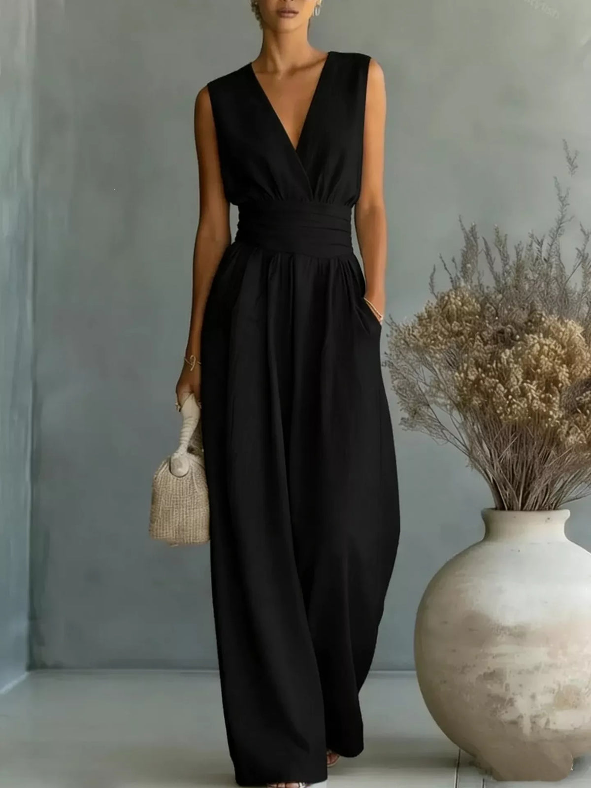 Black sleeveless wide-leg jumpsuit with V-neck wrap bodice and gathered waist