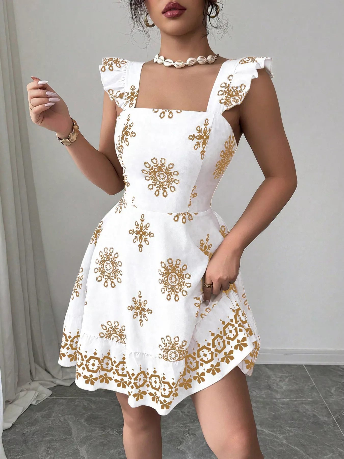 Printed bow-back square-neck mini dress in white with gold motifs and ruffle cap sleeves