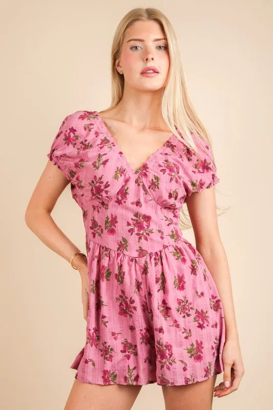 Pink floral printed ruffle romper with V-neck, puff sleeves, and tiered skirt hem