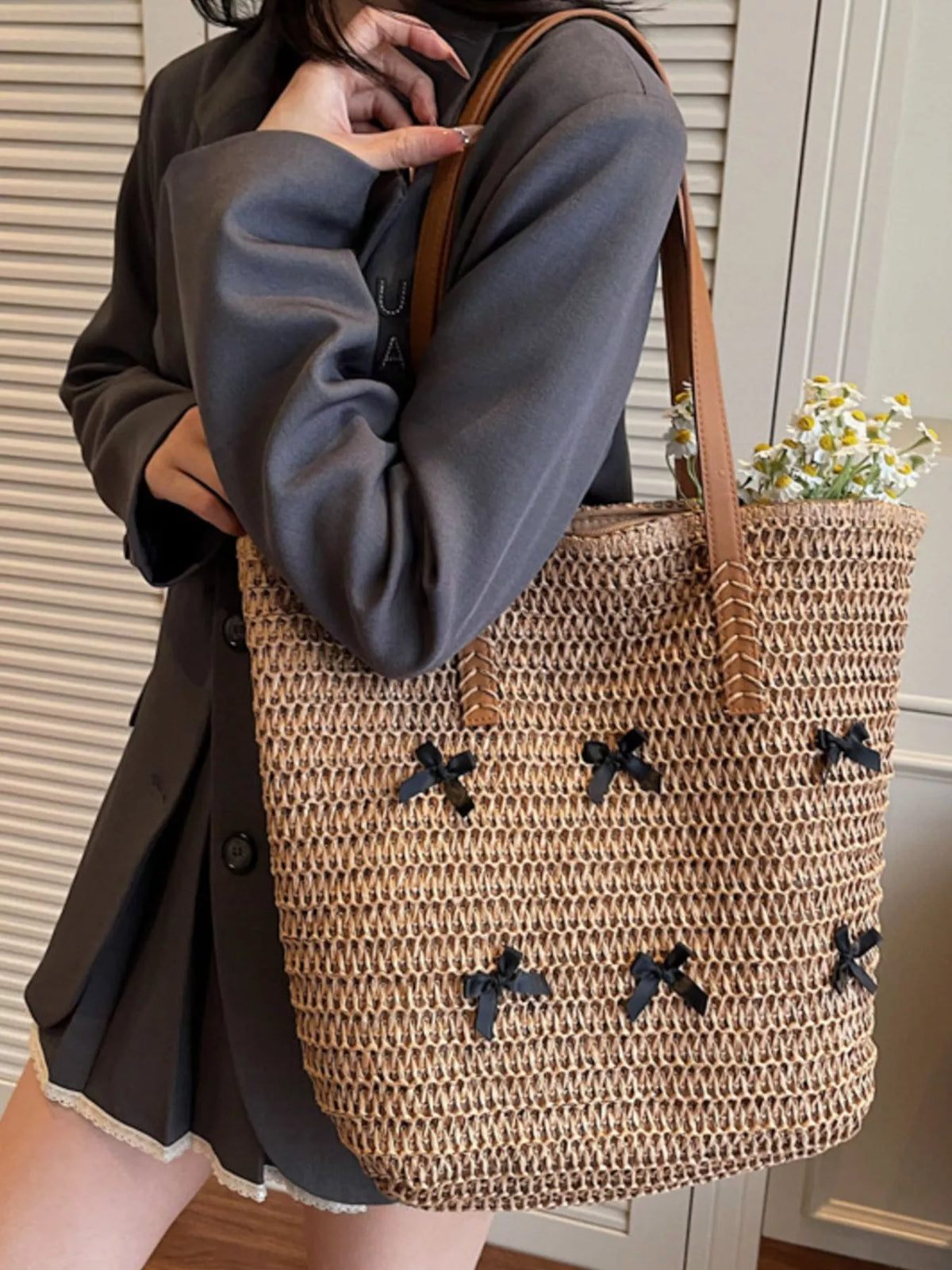 Woven straw tote bag in caramel with bow applique pattern and side carry handles