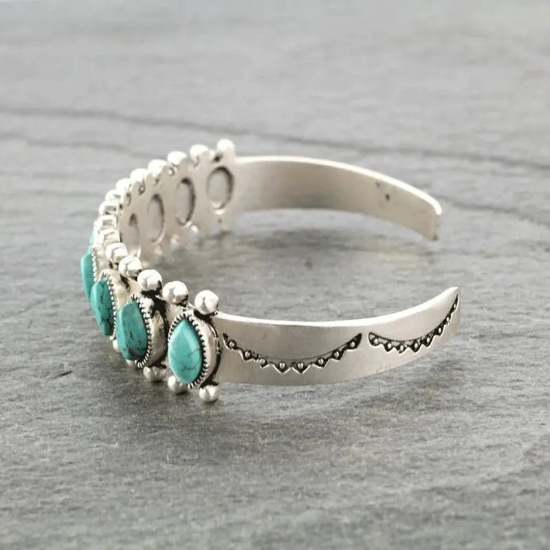 Open cuff bracelet with oval turquoise stones and silver scalloped edge detailing