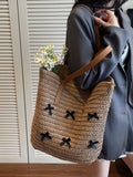 Caramel woven straw tote with bow applique pattern and small bouquet tucked inside