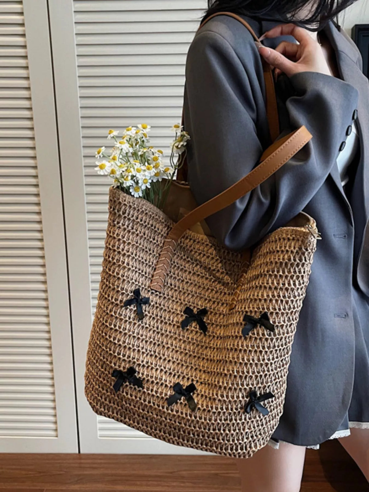 Caramel woven straw tote with bow applique pattern and small bouquet tucked inside