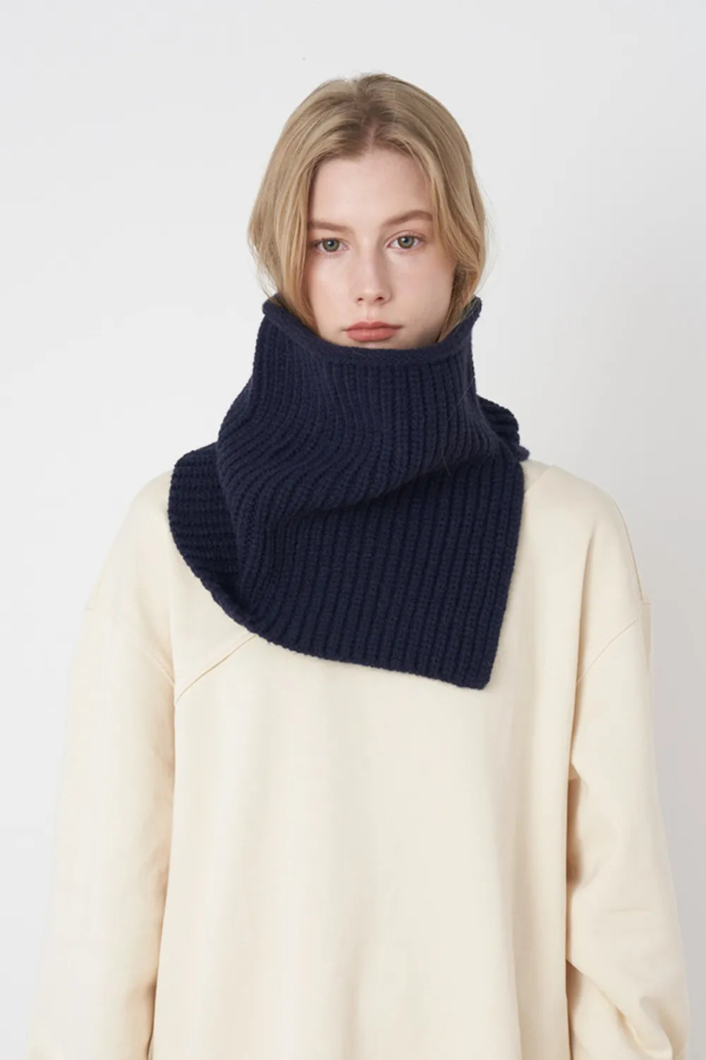 Dark navy ribbed knit pullover scarf worn as a folded cowl at the neck
