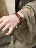 Double-layer agate bead bracelet in burgundy red with two teal accent beads on wrist