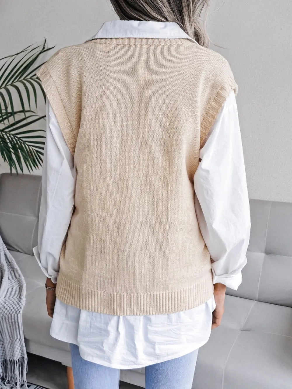 Cream openwork V-neck sweater vest, sleeveless knit; back view with ribbed hem.
