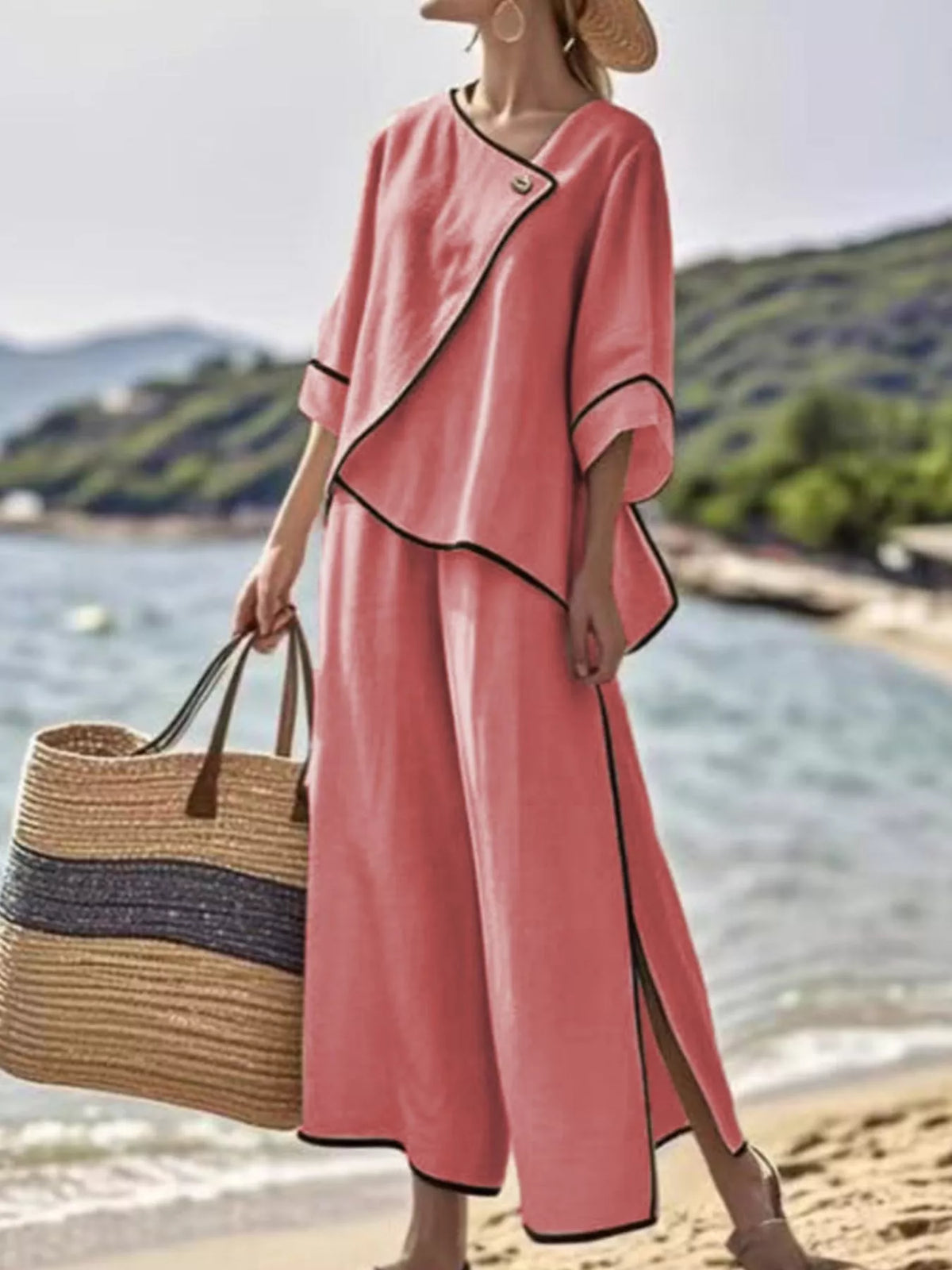 Coral-red two-piece pants set with black contrast trim and wrap-style neckline