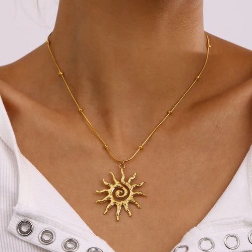 Gold-plated sun pendant necklace with thin chain and small swirl sun charm