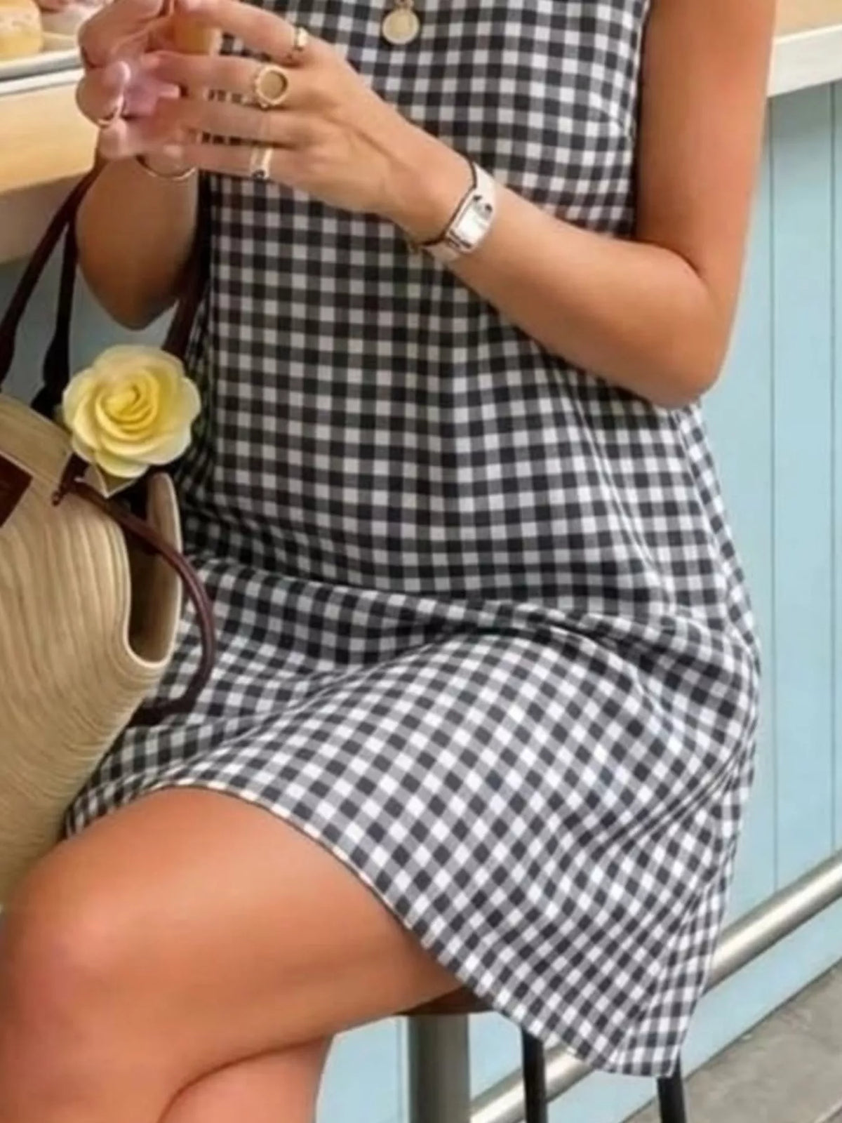 Black and white gingham sleeveless A-line mini dress, check pattern hem