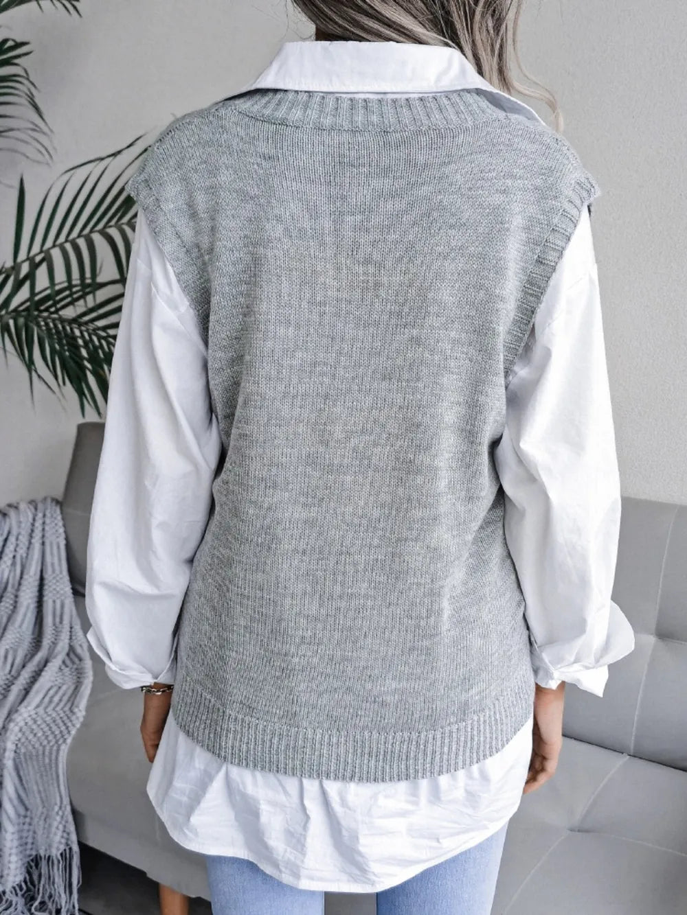 Light gray openwork V-neck sweater vest, sleeveless knit; back view with ribbed neckline.