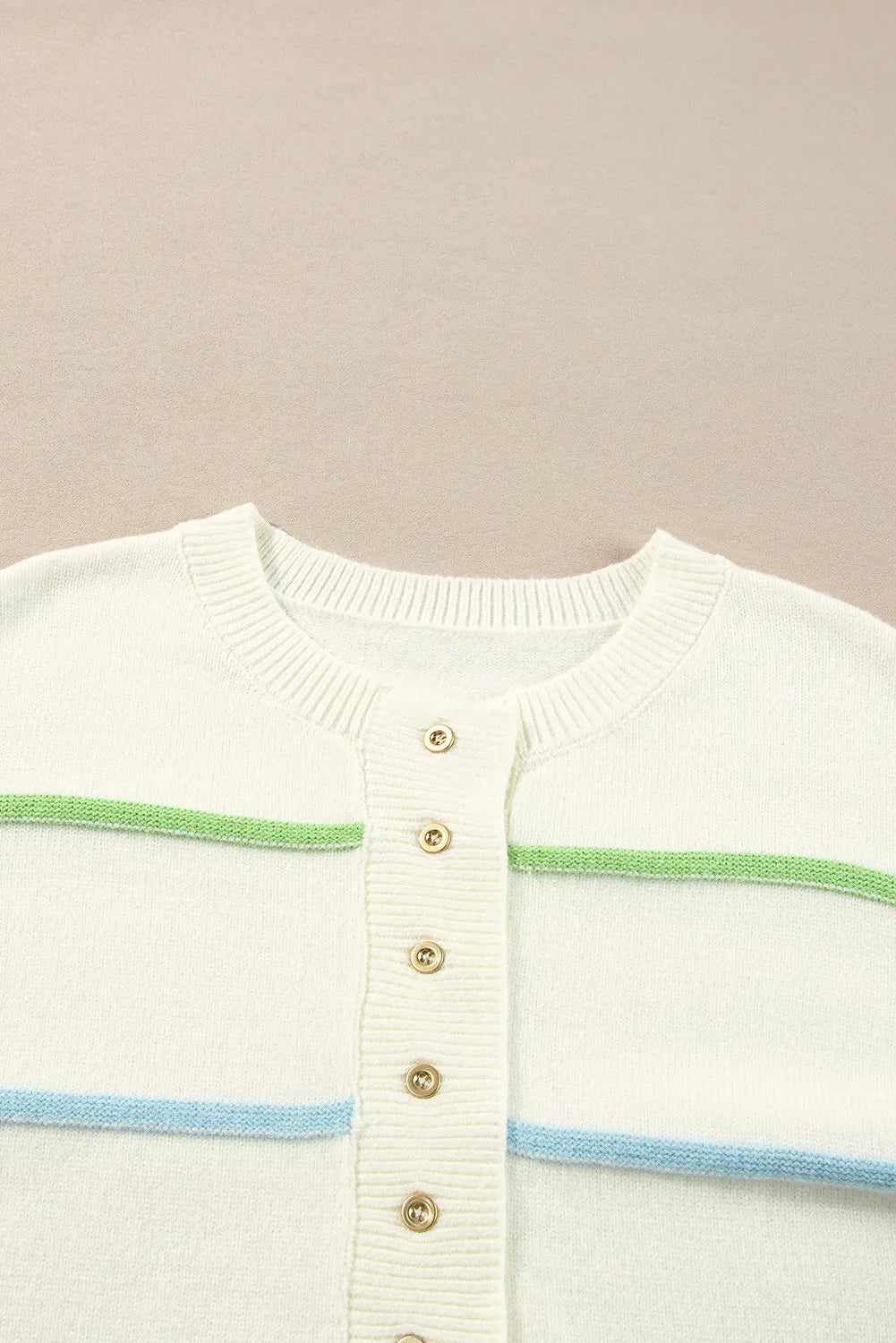 Ivory sweater knit close-up: round neckline, half-button placket with gold buttons and stripe bands