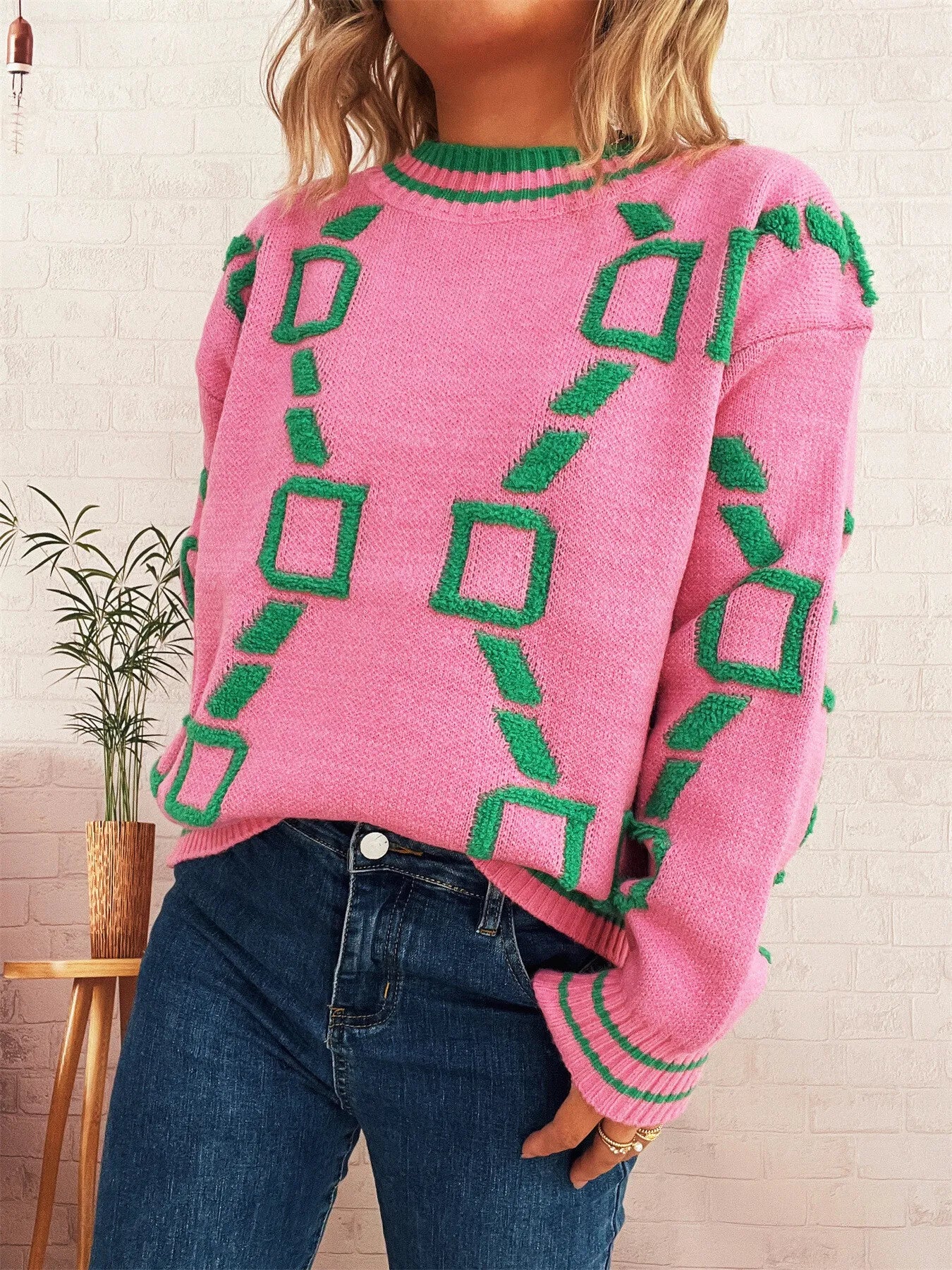 Pink long-sleeve sweater with green geometric square pattern, ribbed collar and cuffs