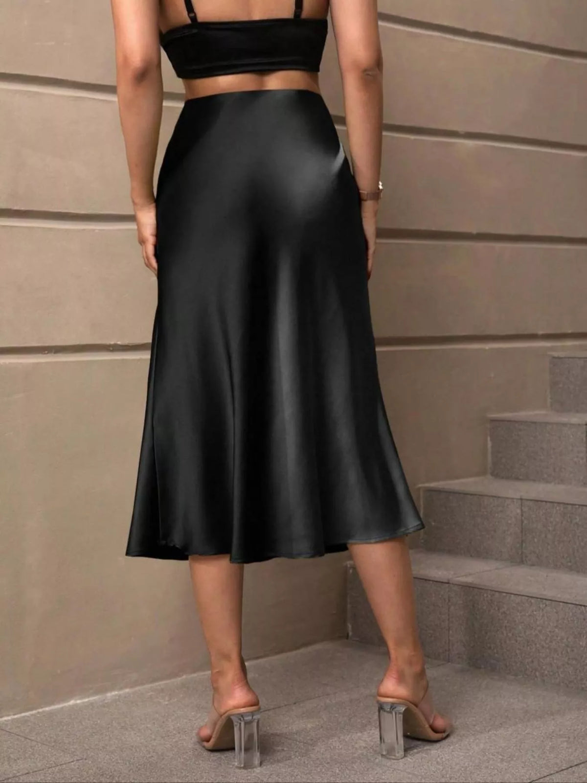 Black satin midi skirt with pleated-looking flare and mid-calf length