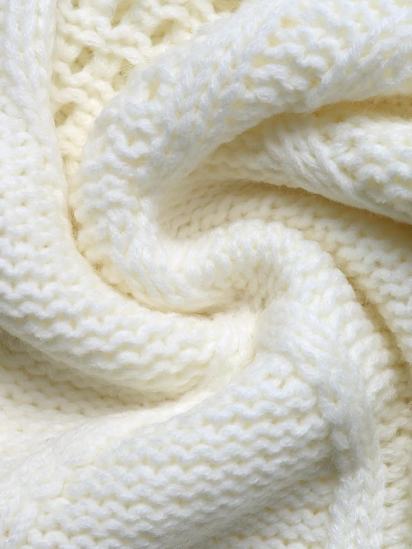 Ivory cable knit fabric detail with raised stitch texture and soft drape