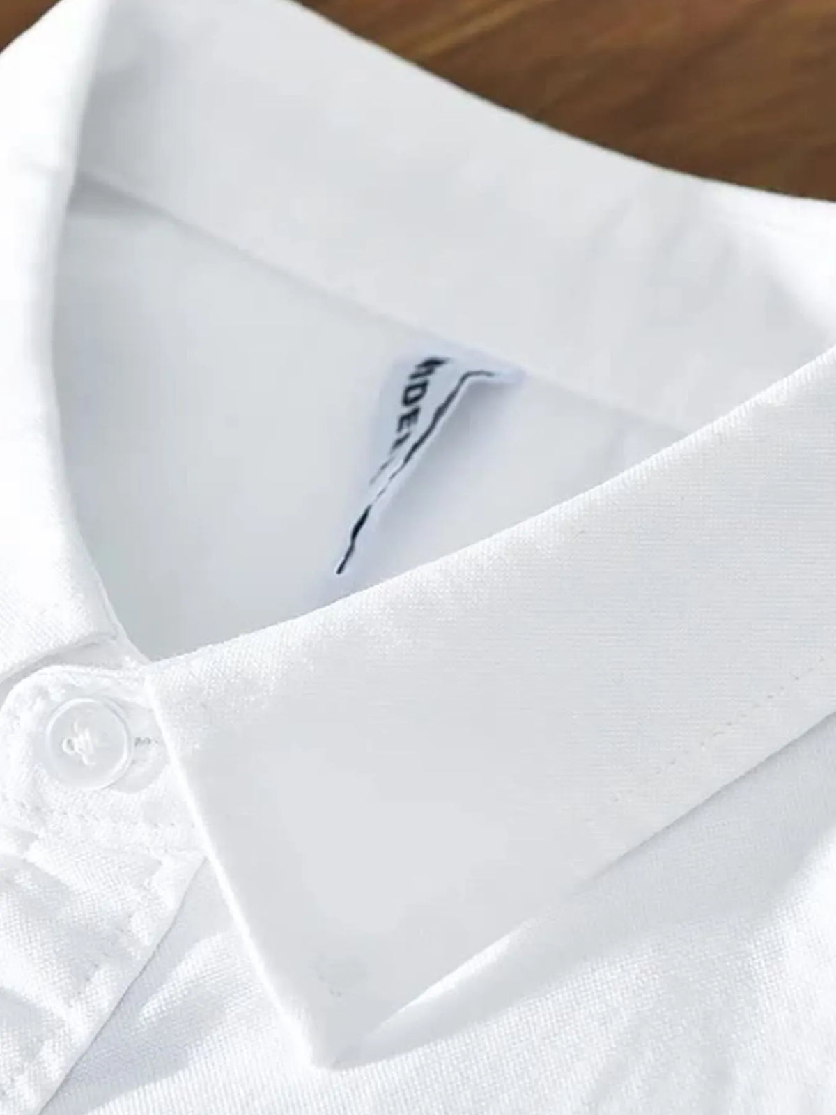 Men's white button-up shirt neckline with inner brand label