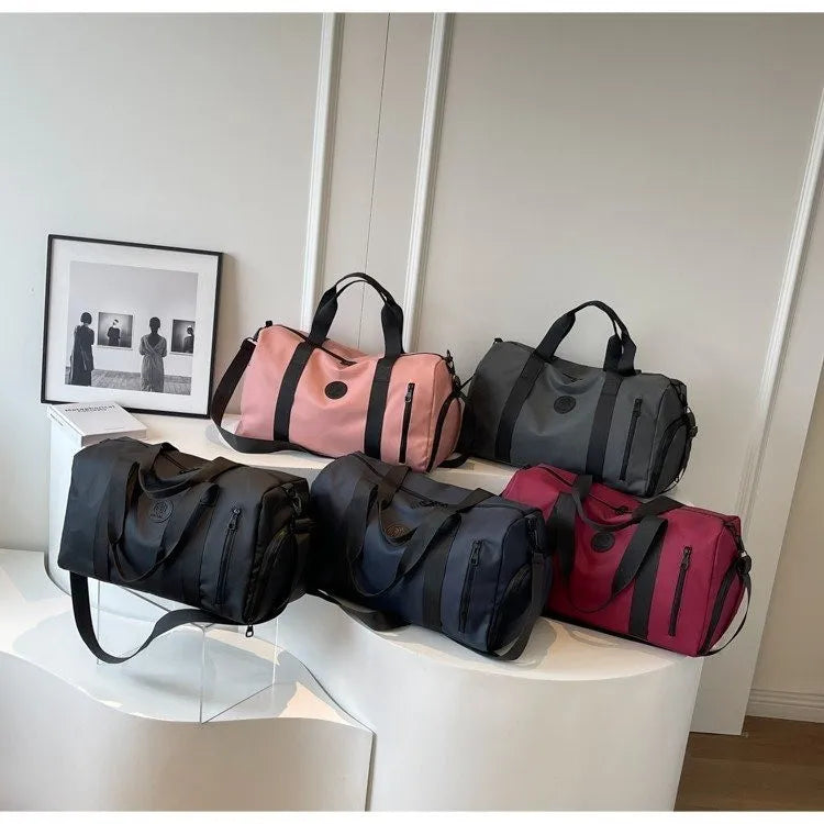 Large waterproof duffel bag in dusty pink with black straps and side zipper pockets
