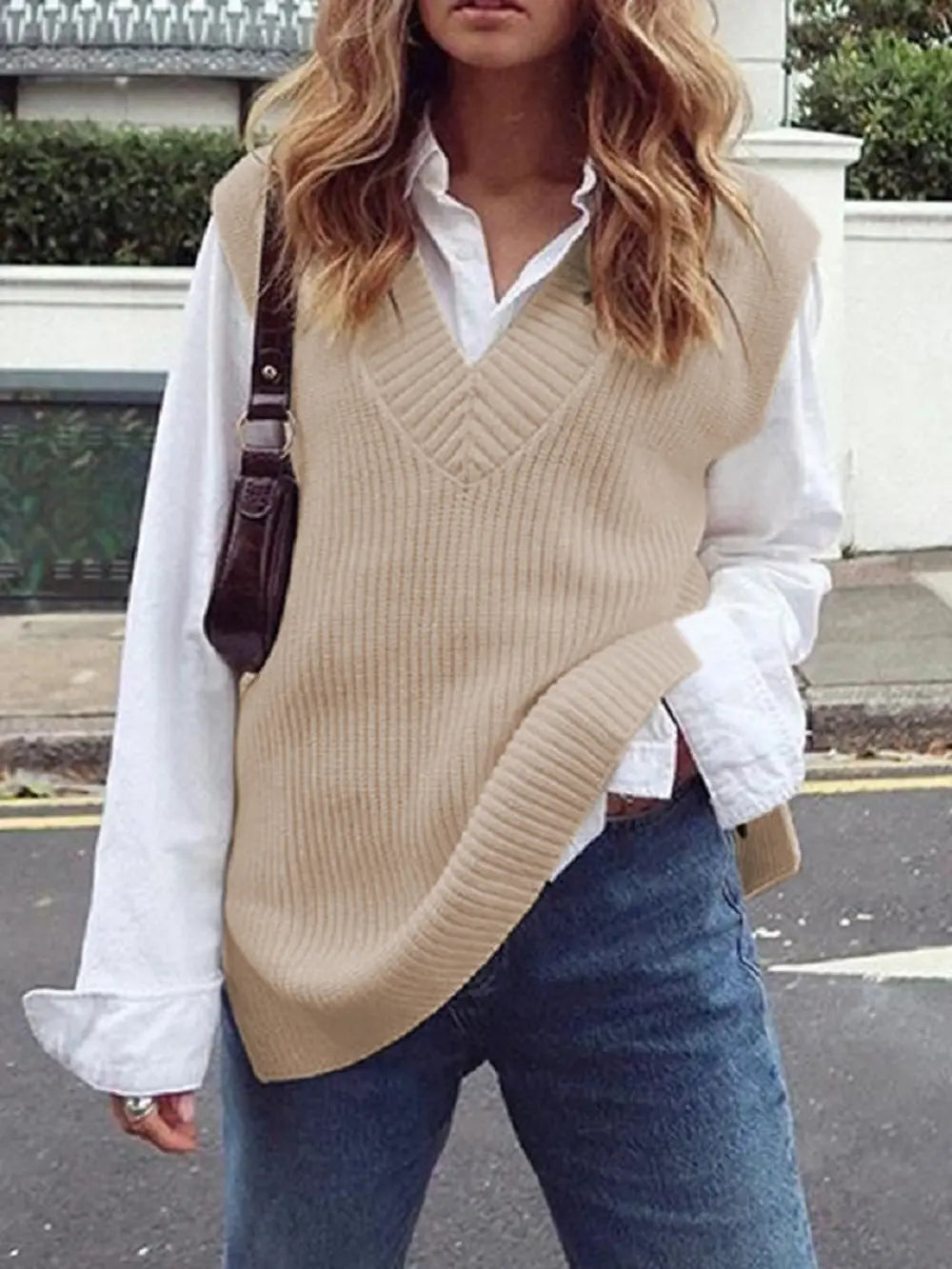 Cream ribbed V-neck sleeveless sweater vest with chevron knit texture.