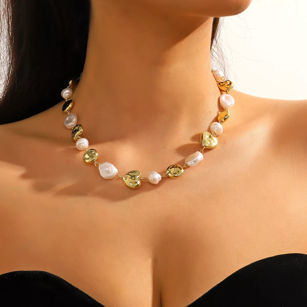 Pearl chain necklace with mixed gold-tone and pearl beads, worn on the neck