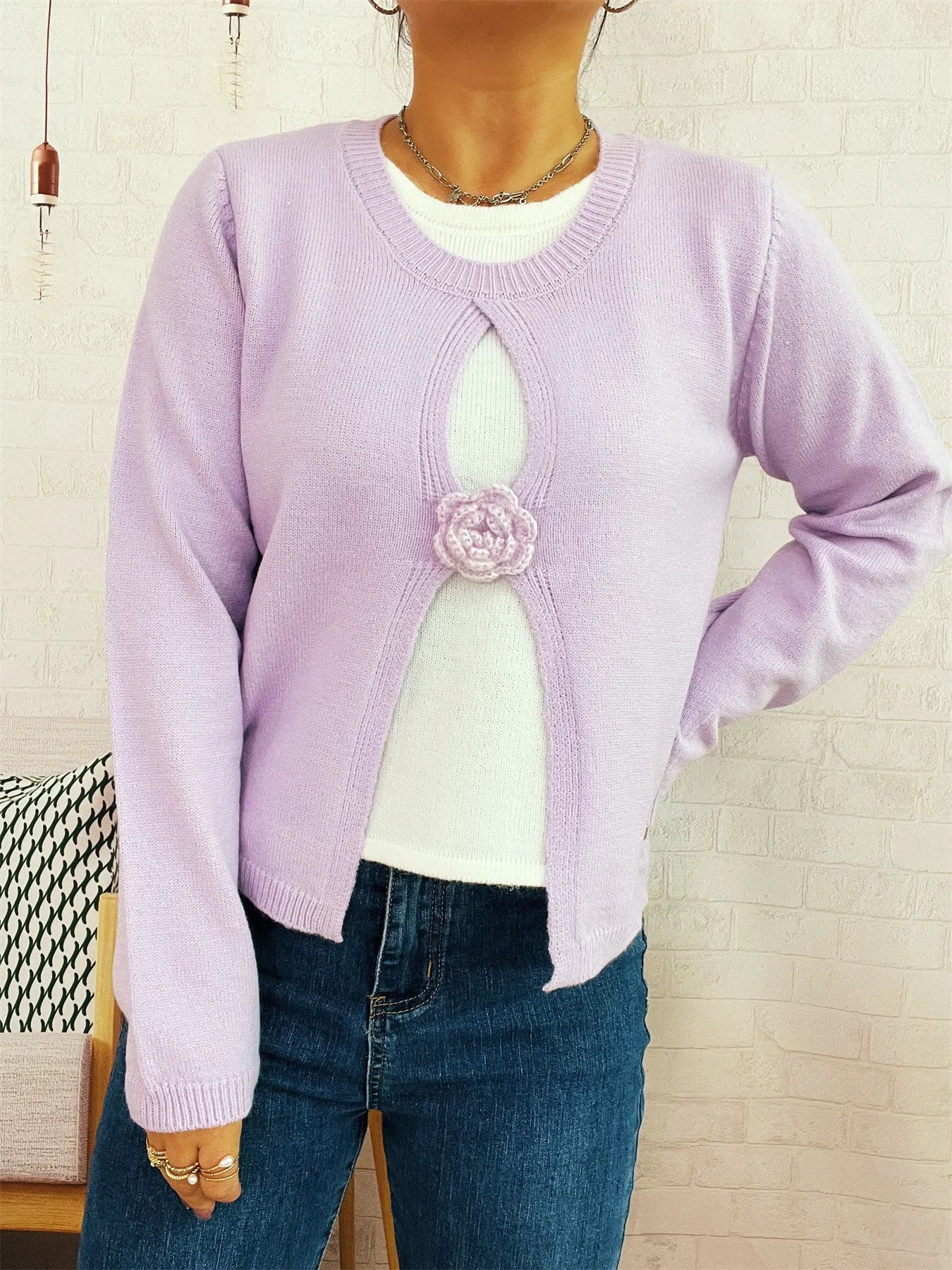 Purple round-neck sweater with white contrast panel and floral appliqué at center