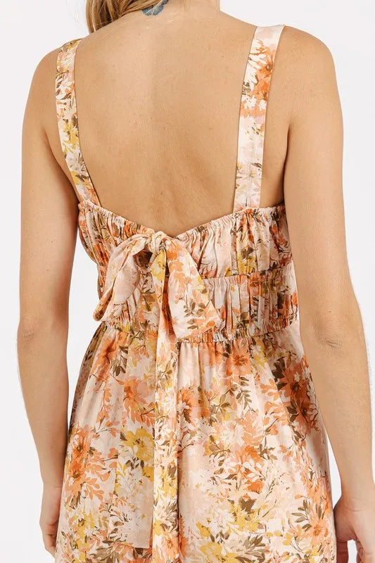 Peach floral open-back sleeveless jumpsuit with gathered waist and tied bow detail