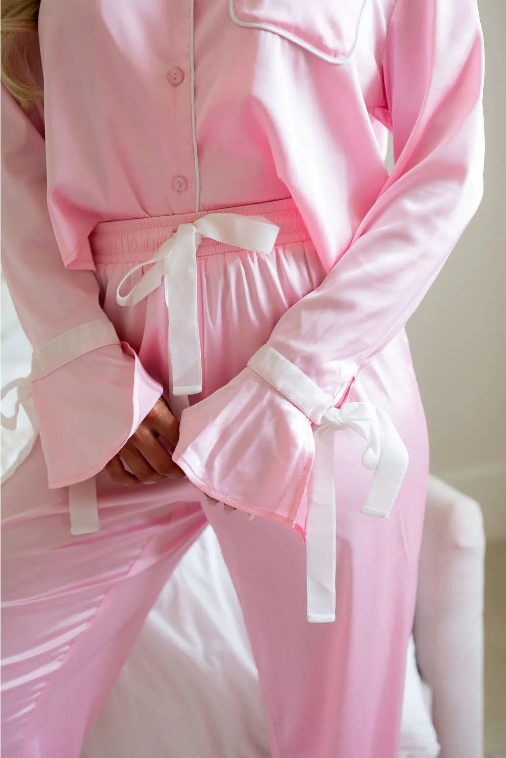 Blush pink lounge set close-up: button-front top, drawstring waist, ruffle cuffs