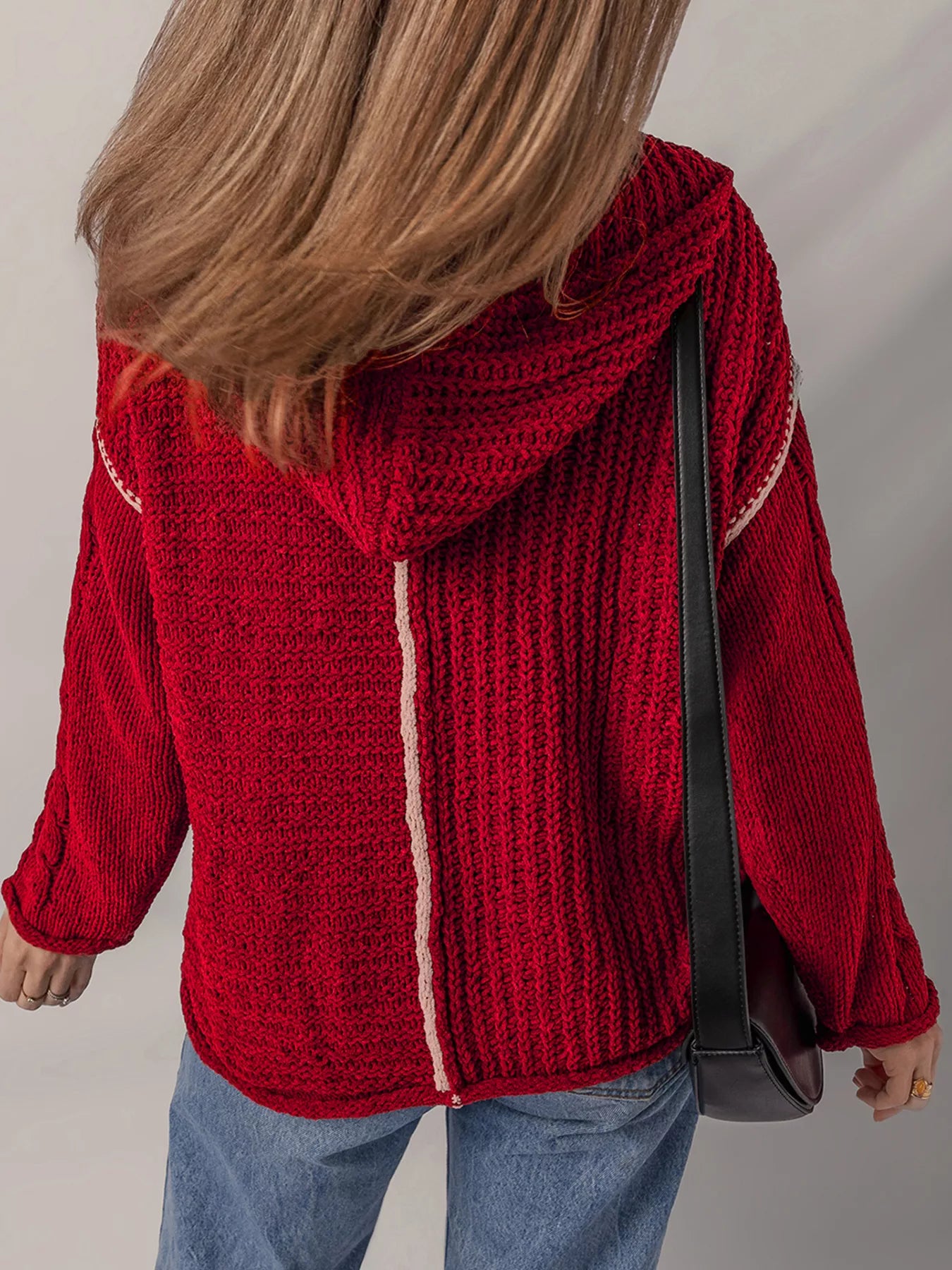 Deep red hooded sweater back with white vertical trim and dangling drawstring strings