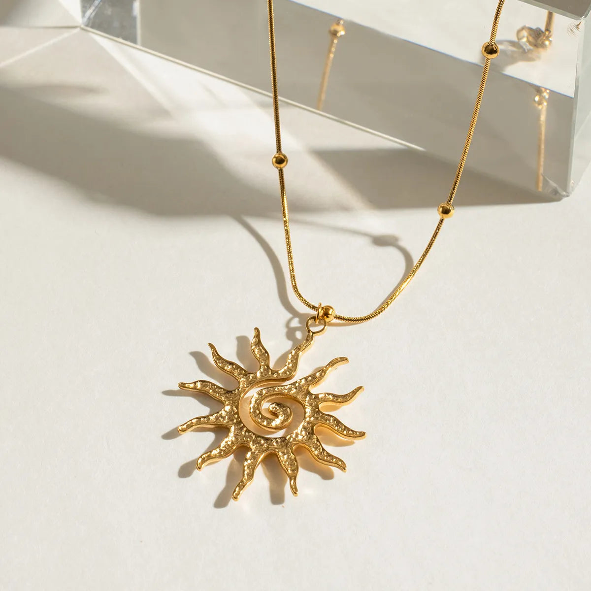 Gold-plated sun pendant necklace with long chain and detailed sun charm pendant