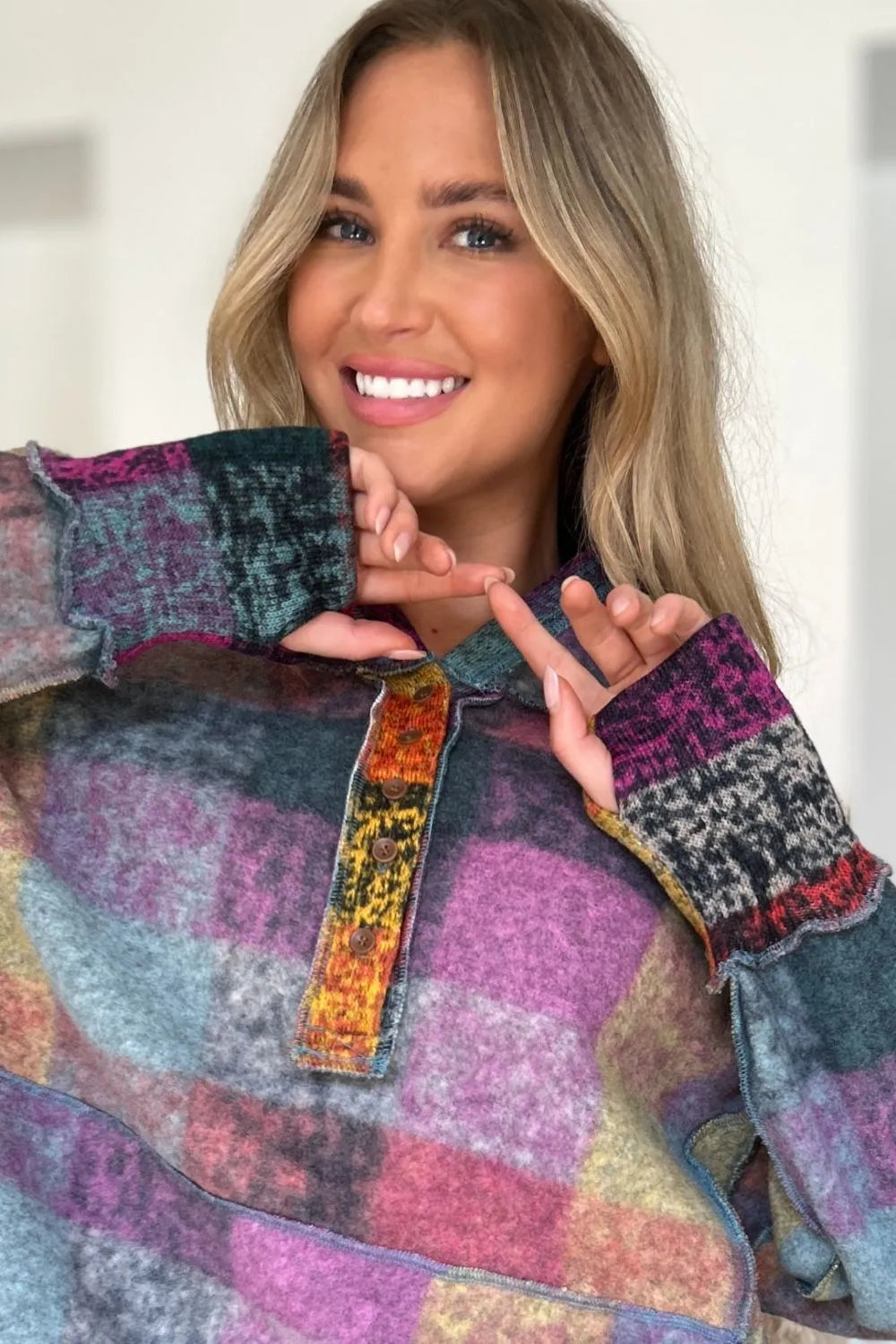 Plaid fleece hoodie chest detail with hood, quarter-zip placket and colorful multicolor threads.
