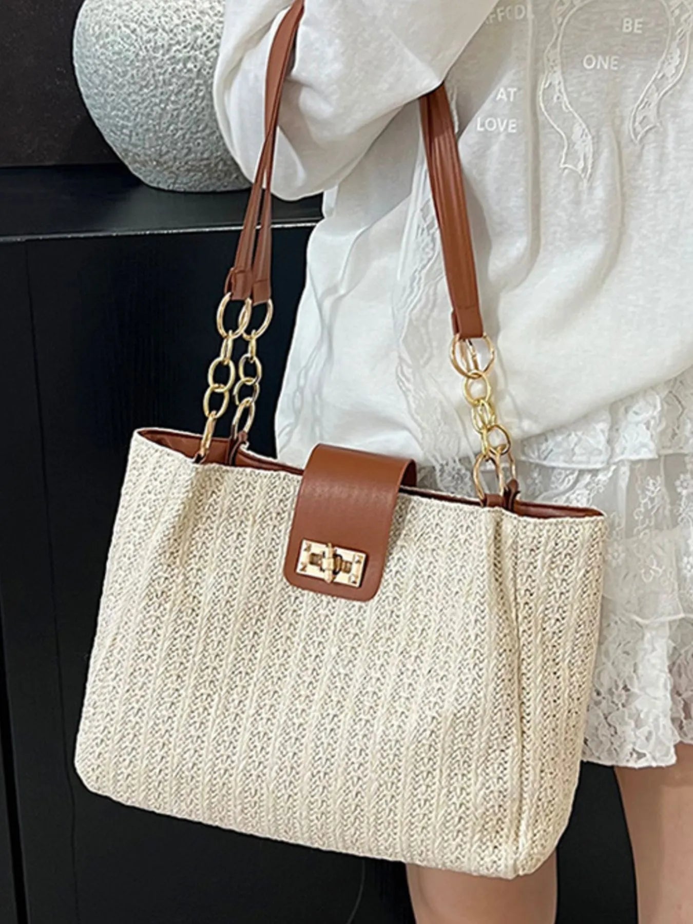 Woven straw shoulder bag with brown leather straps and gold-tone chain, beige woven body