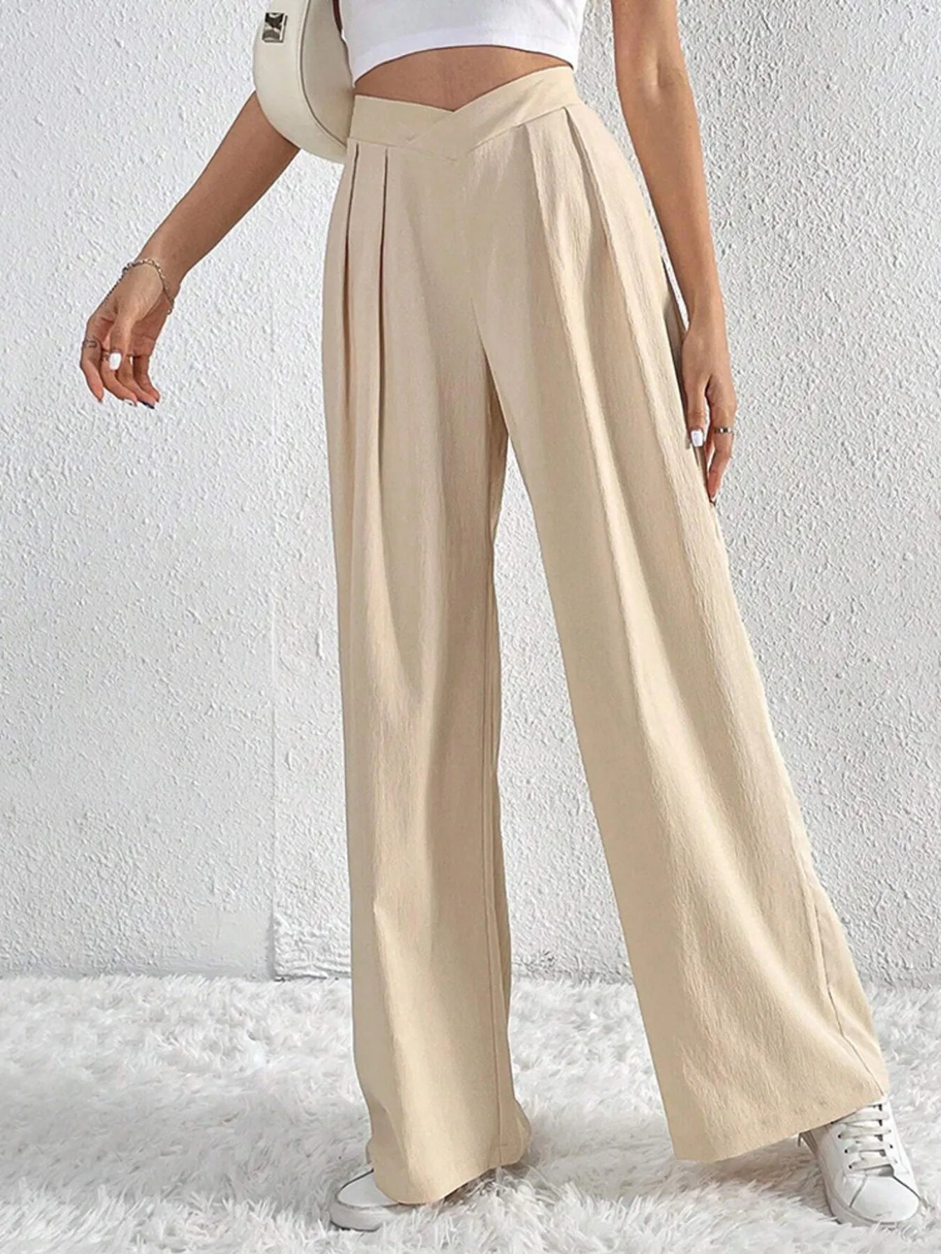 Beige wide-leg pants with ruched V-waist and relaxed pleated legs