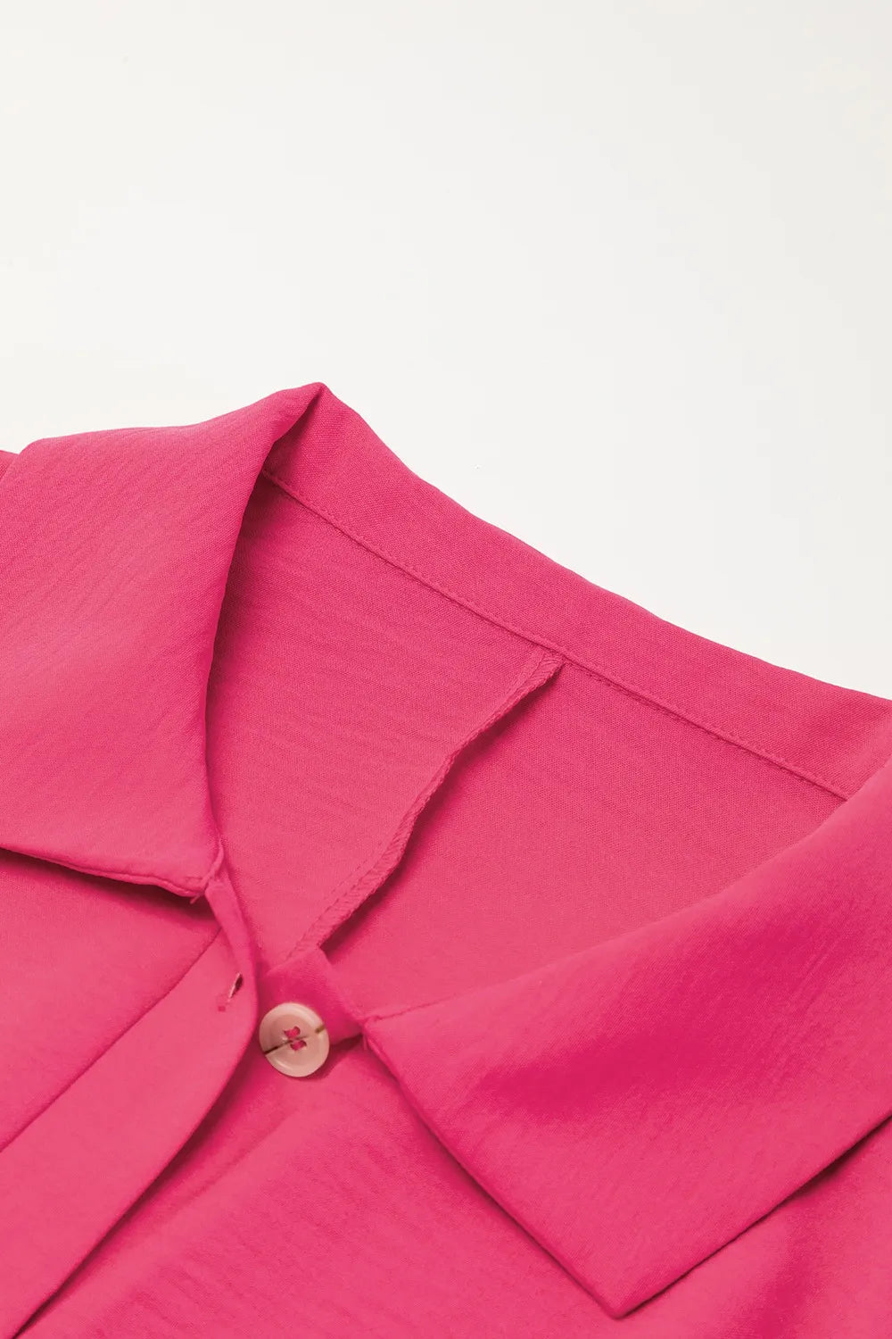 Hot pink collared romper neckline with partial button placket and short sleeves