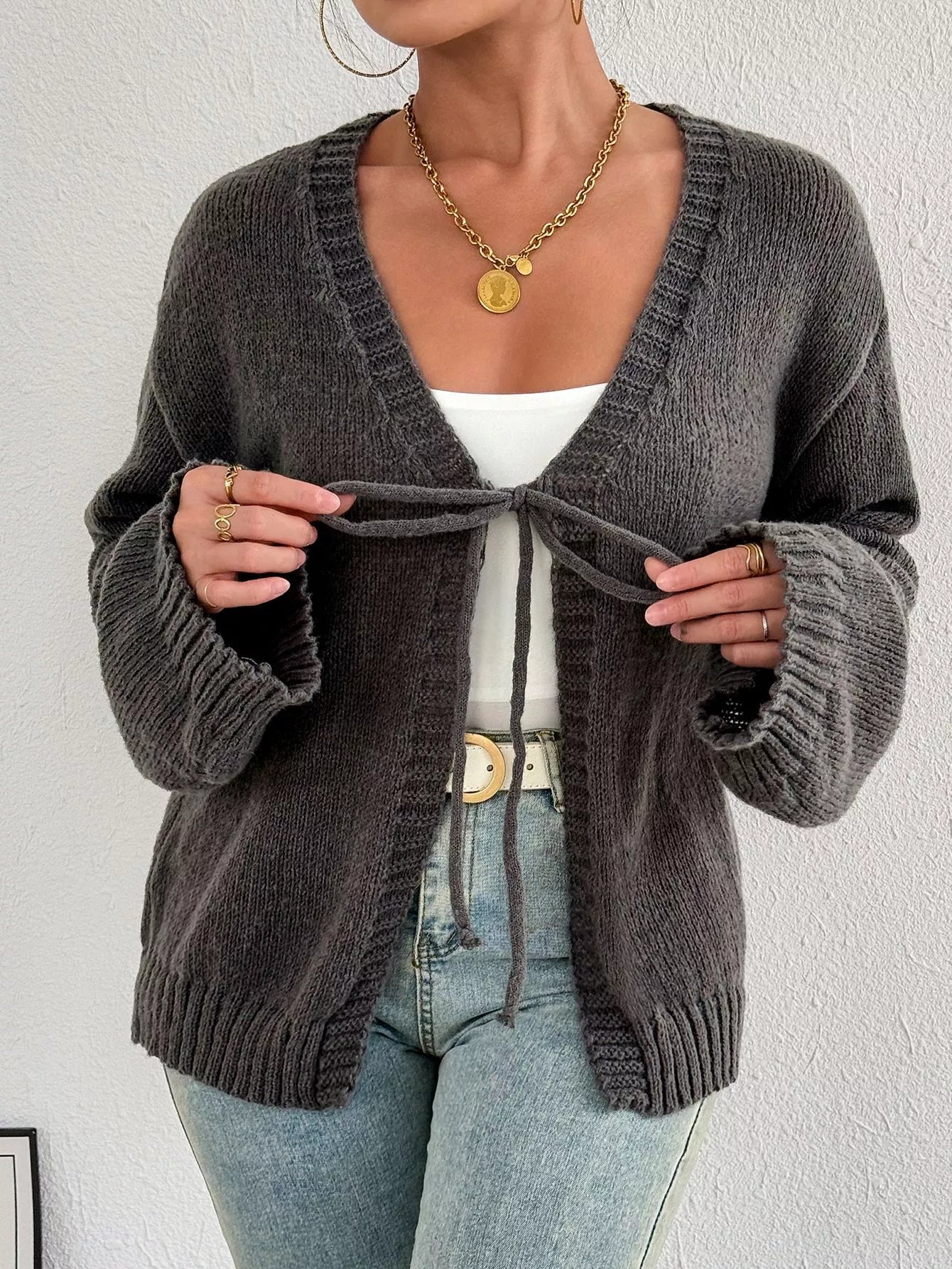 Dark gray tie-front cardigan with neckline knot tie and ribbed cuffs, relaxed fit