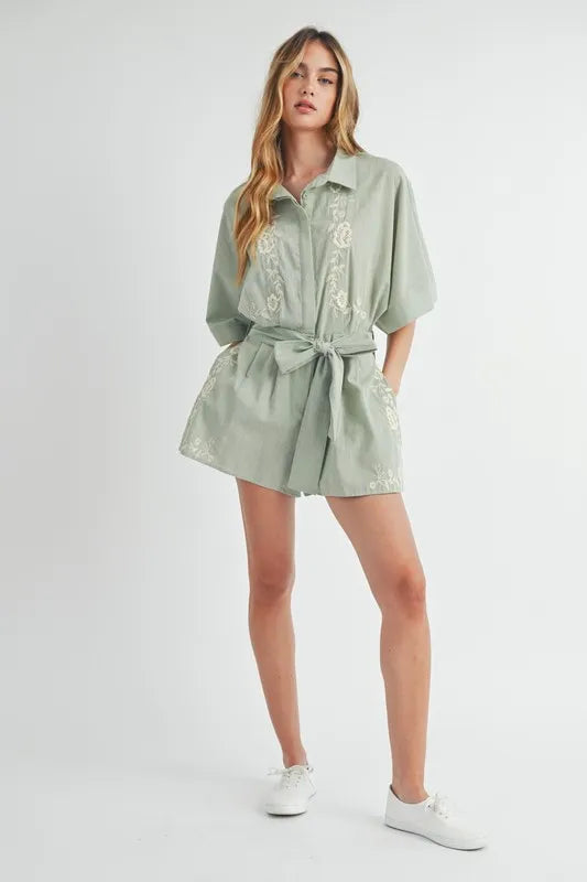 Dusty sage collared button romper with embroidered details and waist tie, front view